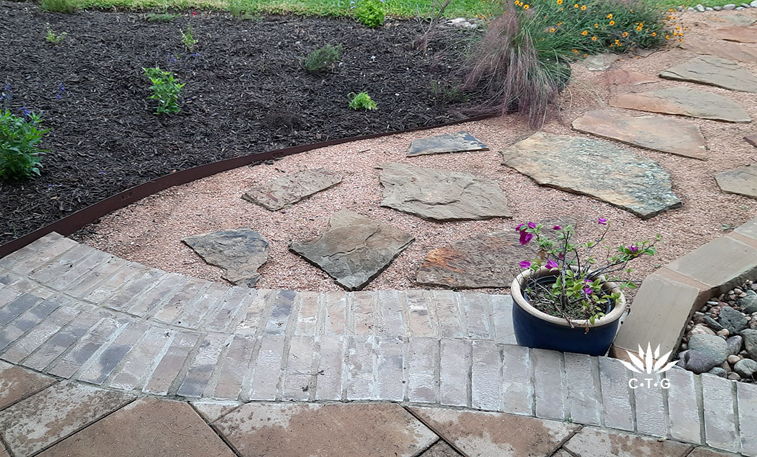 patio tiles with brick edging to crushed granite path laid with flagstones 