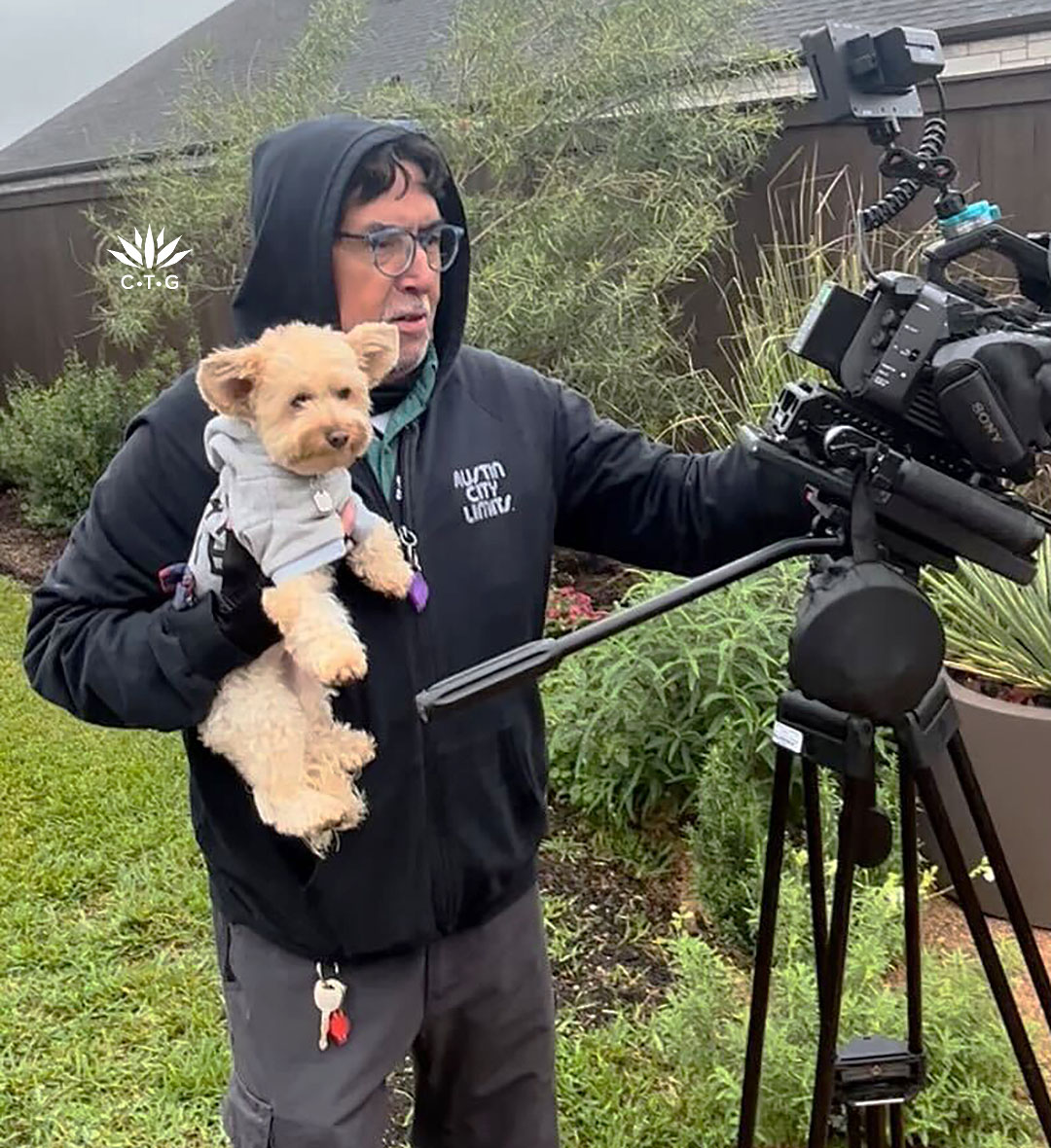 camera operator holding a little dog in front of the camera 