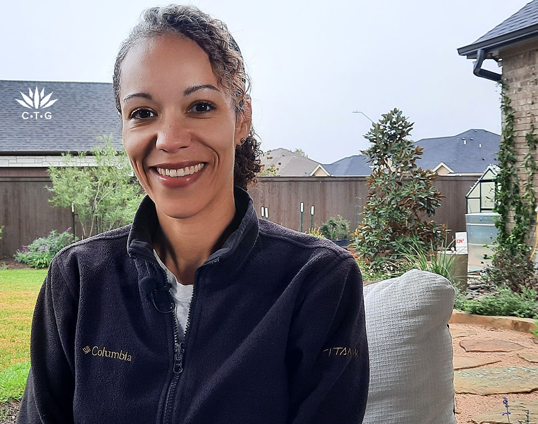 smiling woman against backyard plants 