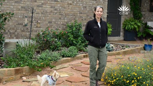 woman on stone garden path with small white fluffy dog