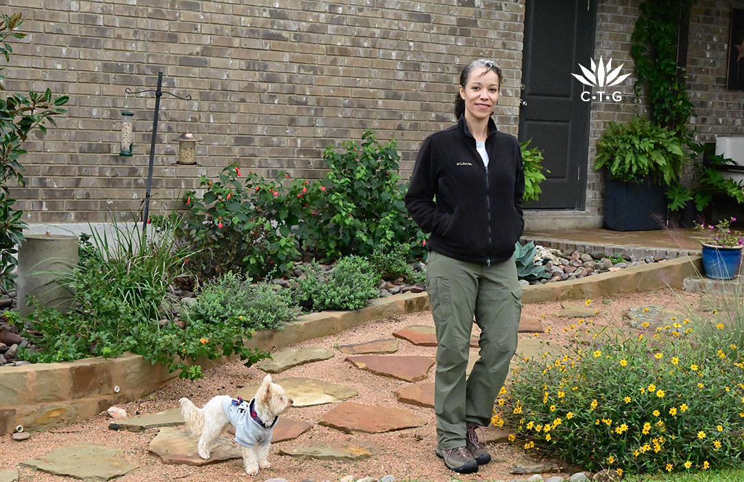 woman on stone garden path with small white fluffy dog 