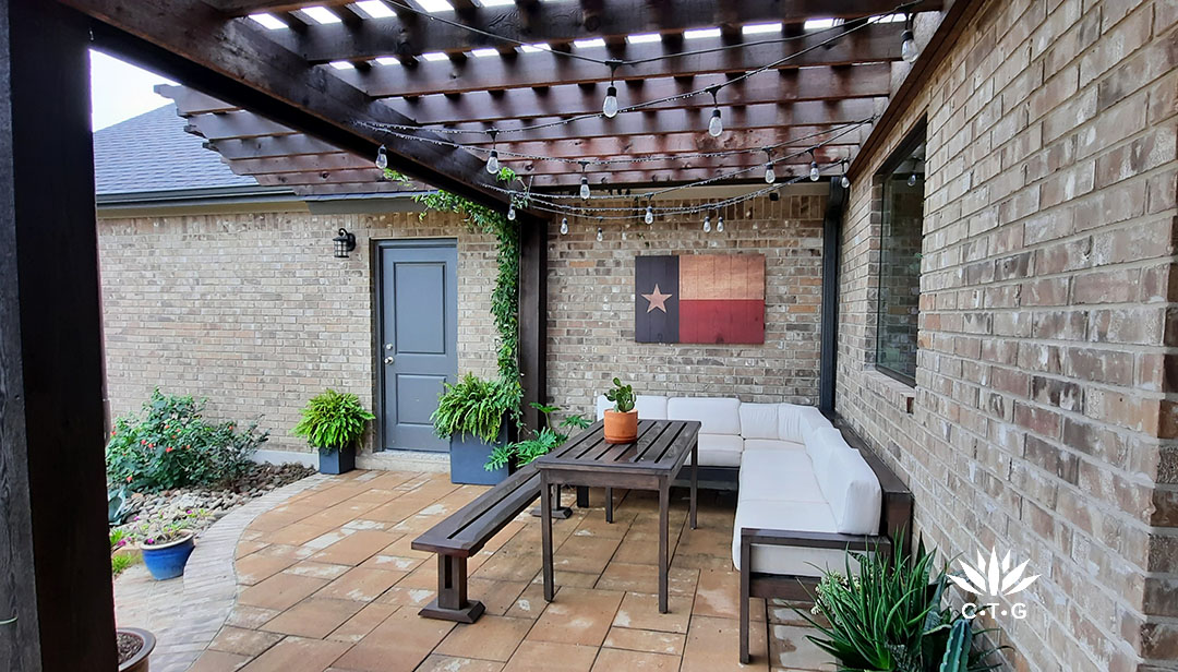 wood slats shade cover over patio with couch and long narrow wood table 