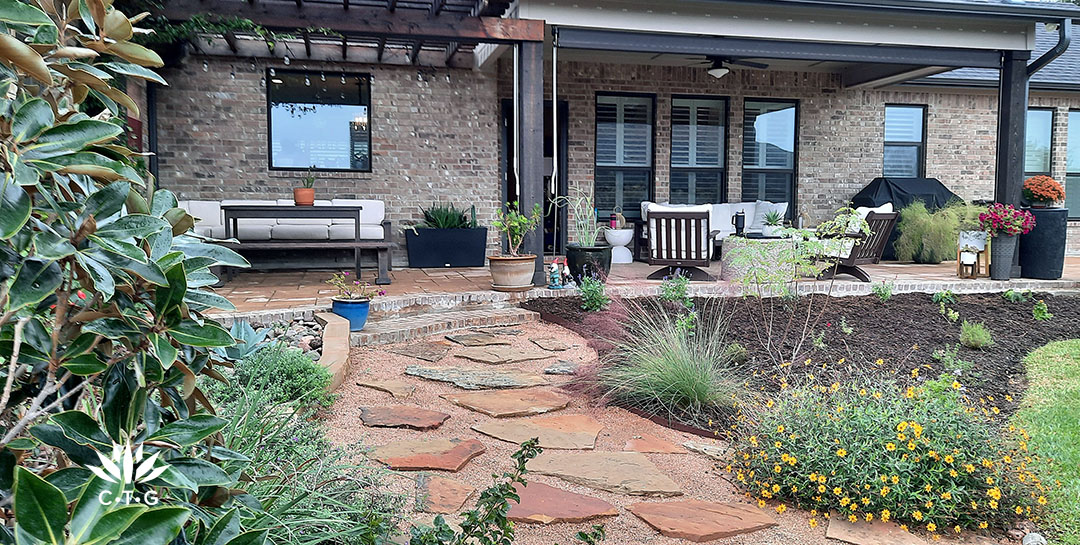 crushed granite path flagstones borderd by plants to long patio along house