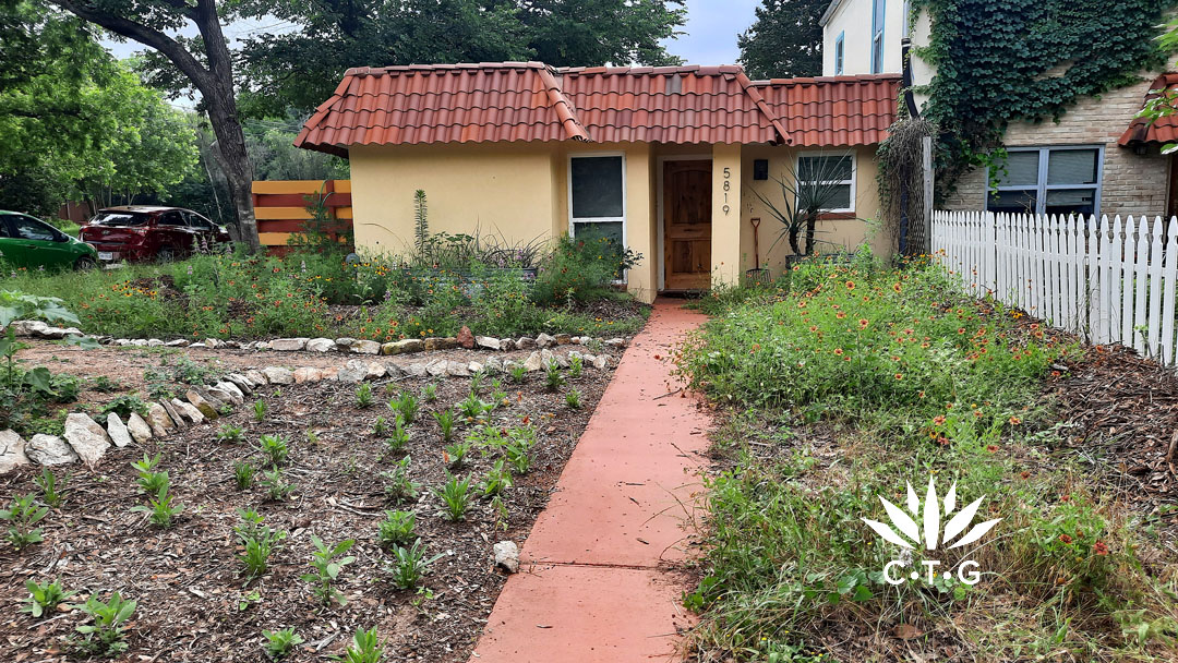 new planting beds and wildflowers in front of small house