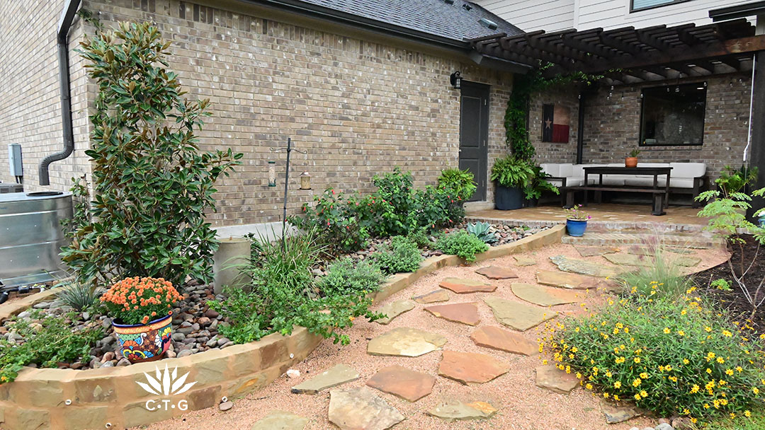 planting bed against house bordered with stone blocks and crushed granite path and flagstones 