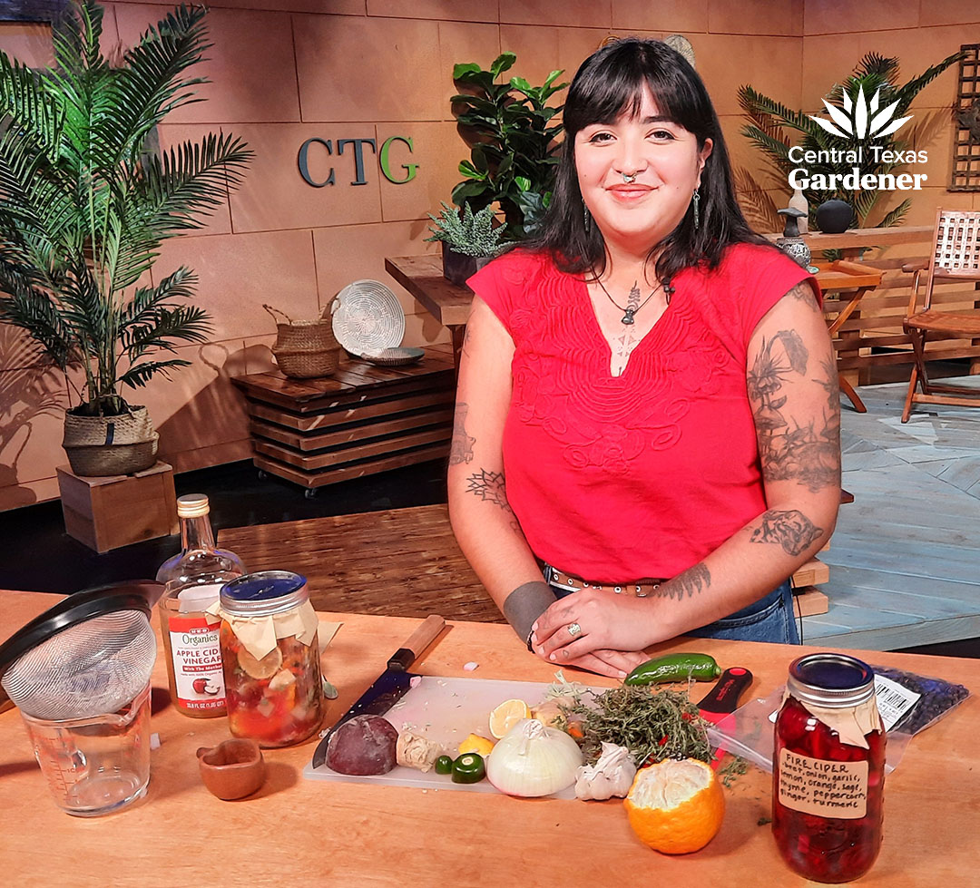 young woman in front of table on TV set with jar and various food ingredients