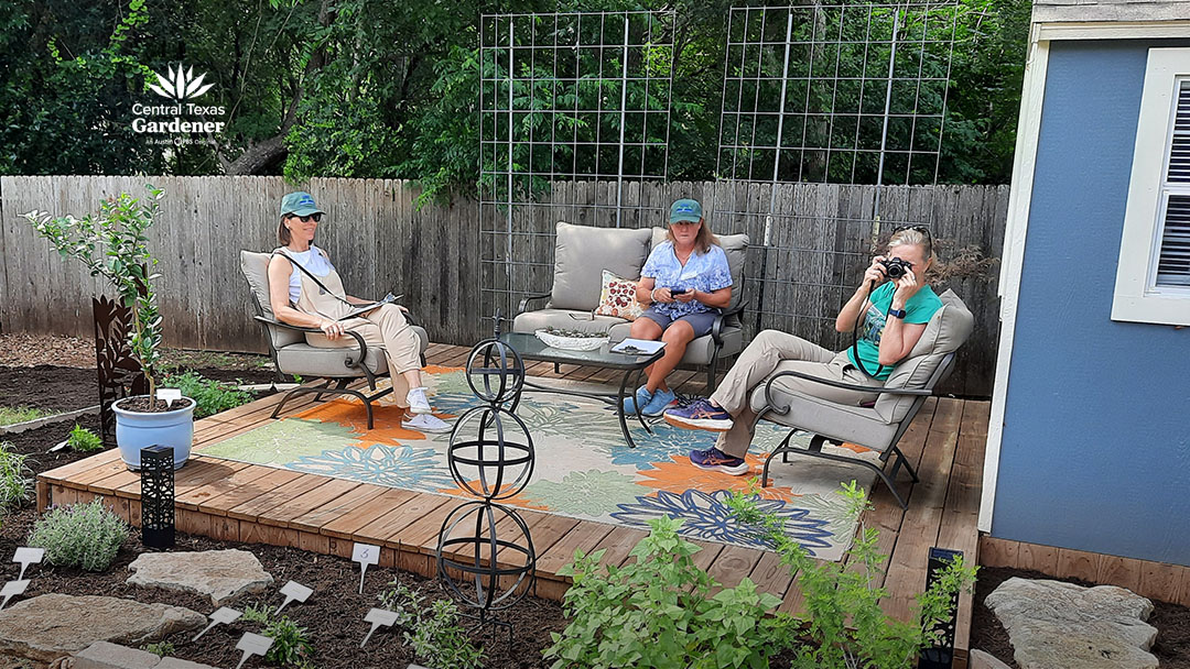 three women on patio deck framed by tall cattle panel