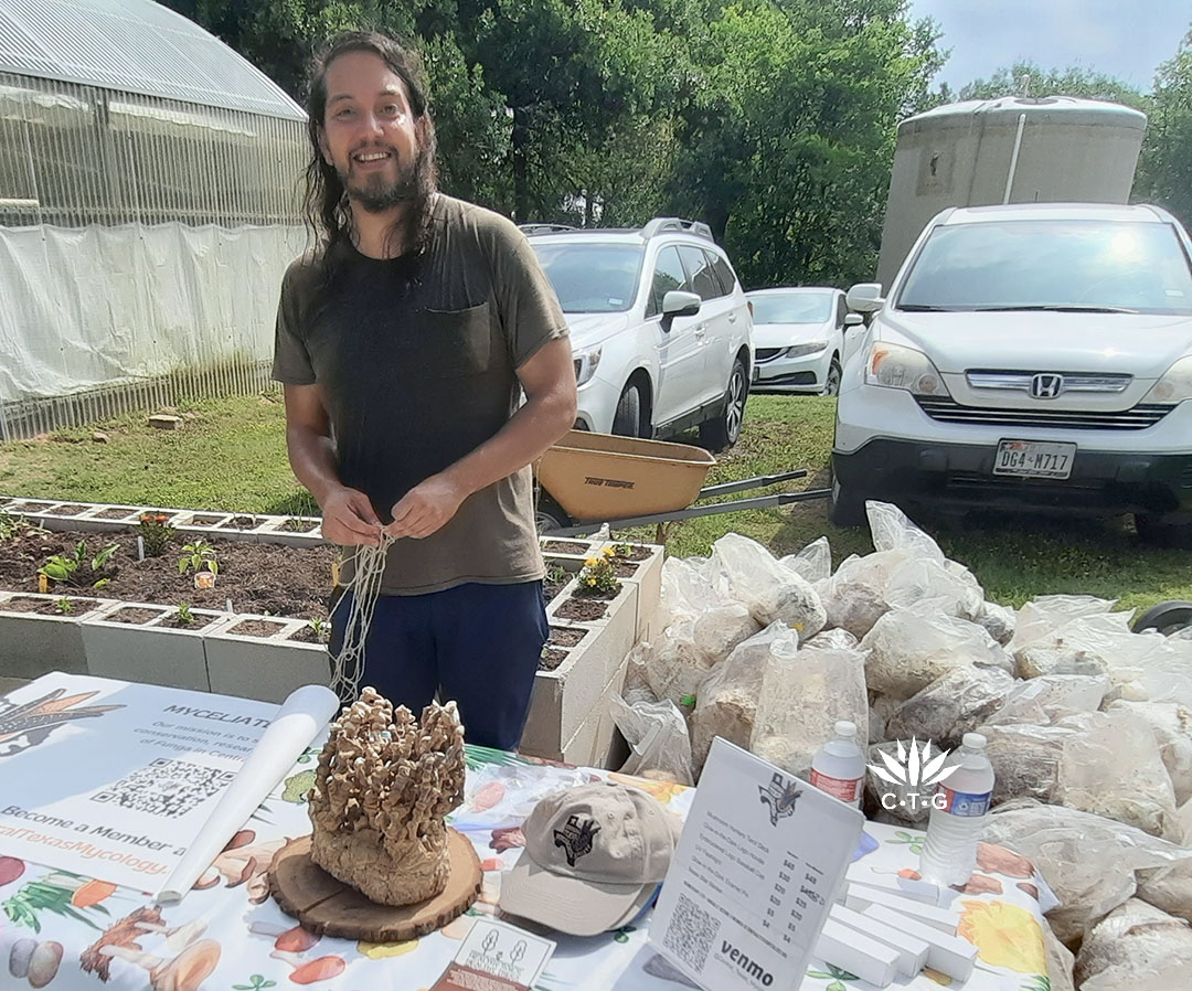 young man behind table with mushroom blocks behind him on the ground