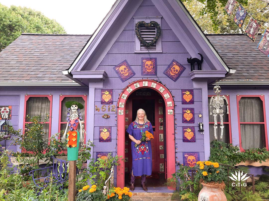 smiling woman in front of purple bungalow