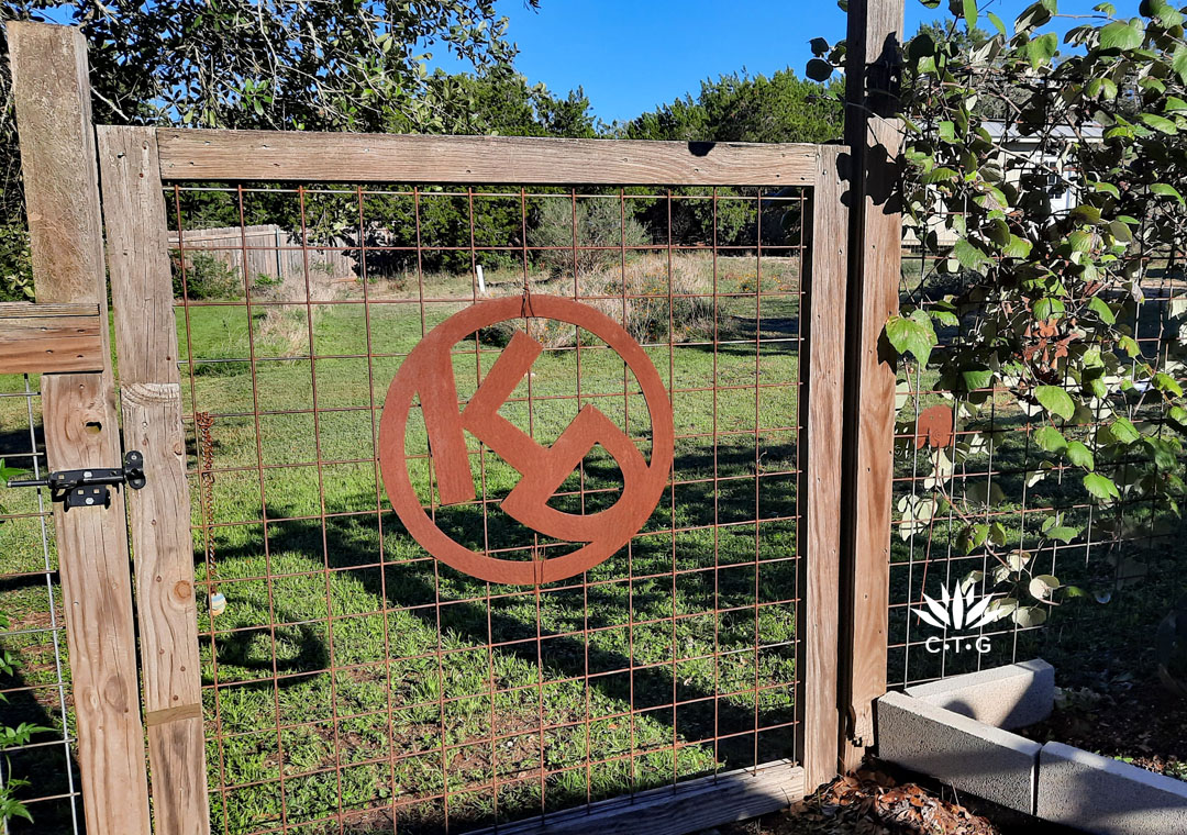 rusty steel brand K and D on cattle panel gate