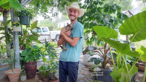 smiling man in front yard holding a cat