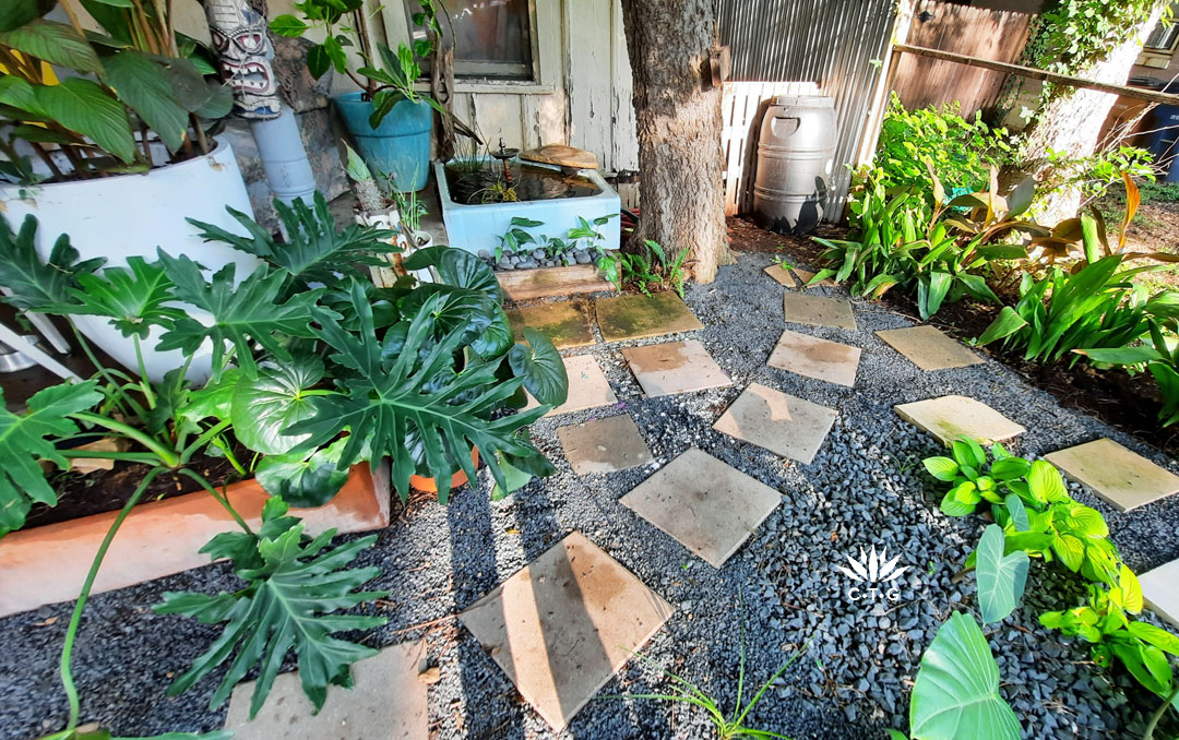 sand colored pavers on black gravel leading to turquoise shower basin pond