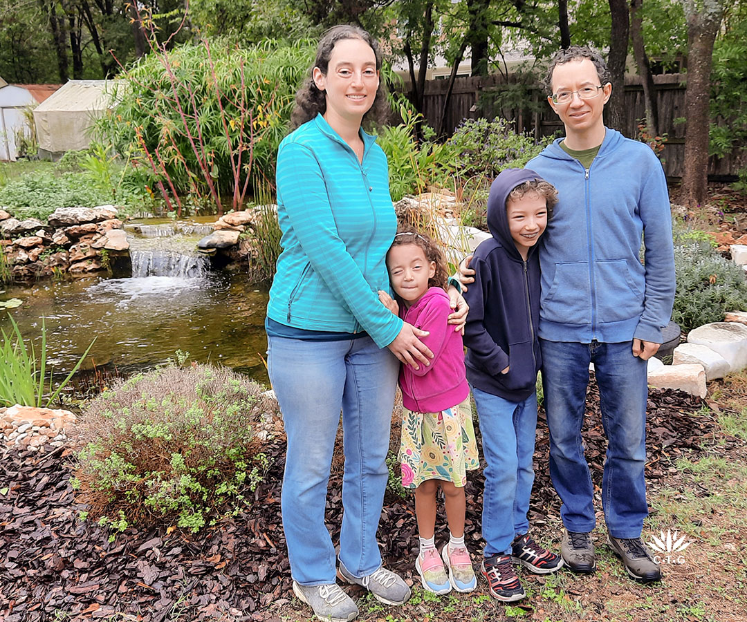 parents with young son and daughter in front of pond 